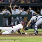 
              Connecticut catcher Matt Donlan, right, tags out Stanford's Drew Bowser during the fourth inning of an NCAA college baseball tournament super regional game Saturday, June 11, 2022, in Stanford, Calif. (AP Photo/John Hefti)
            