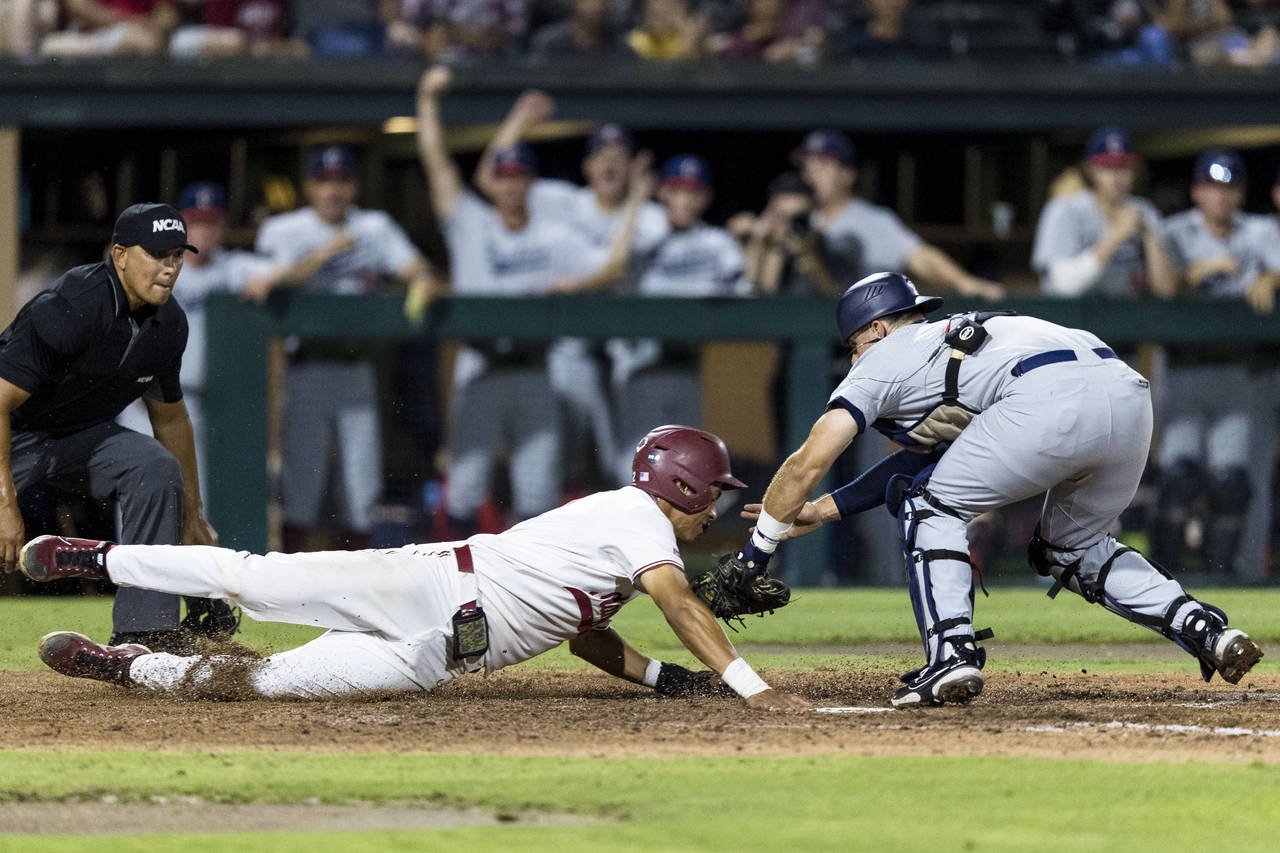Connecticut catcher Matt Donlan, right, tags out Stanford's Drew Bowser during the fourth inning of...