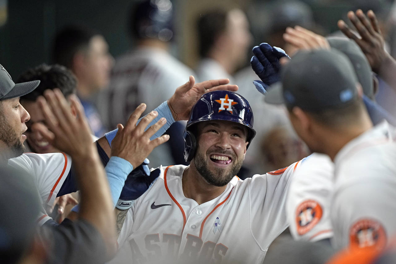 Houston Astros' J.J. Matijevic celebrates with teammates in the dugout after hitting a home run aga...