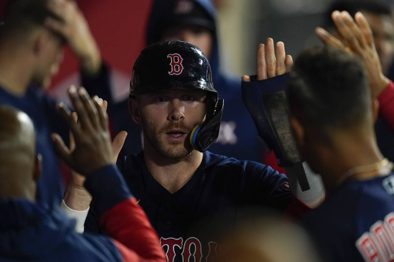 Boston Red Sox's Trevor Story celebrates in the dugout after scoring off of a single hit by Christi...
