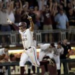 
              Fan and players celebrate as Texas A&M's Trevor Werner scores the winning run against Louisville during an NCAA college baseball super regional tournament game early Saturday, June 11, 2022, in College Station, Texas. (AP Photo/Sam Craft)
            