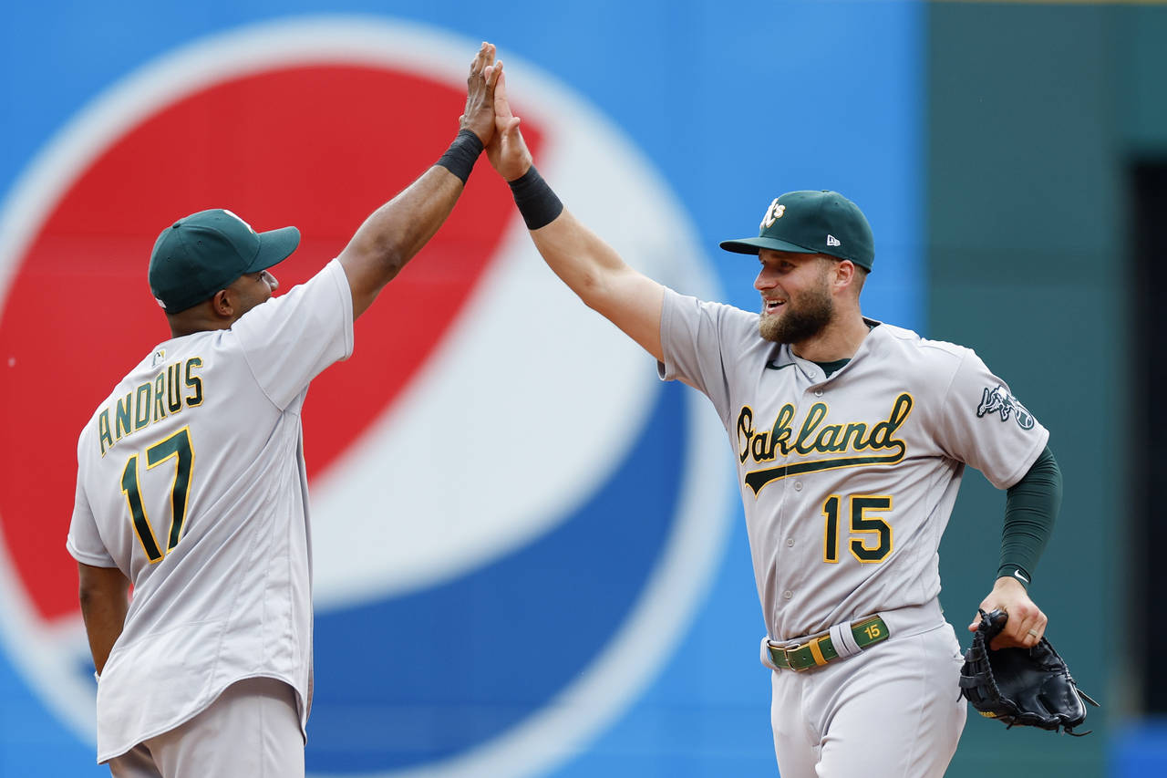Oakland Athletics' Seth Brown (15) and Elvis Andrus (17) celebrate a win over the Cleveland Guardia...