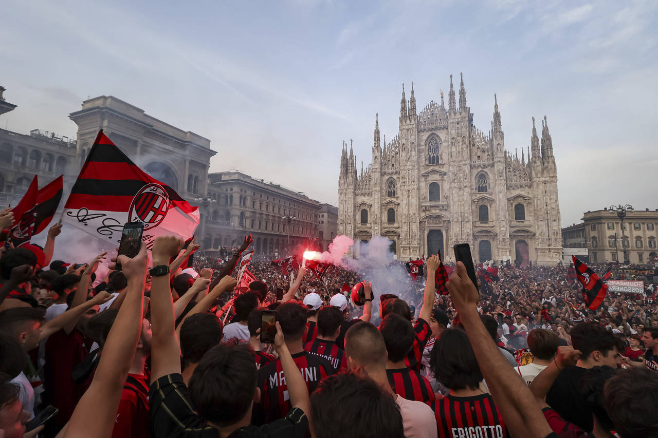 AC Milan fans celebrate in Piazza Duomo square after a Serie A soccer match between Sassuolo and AC...