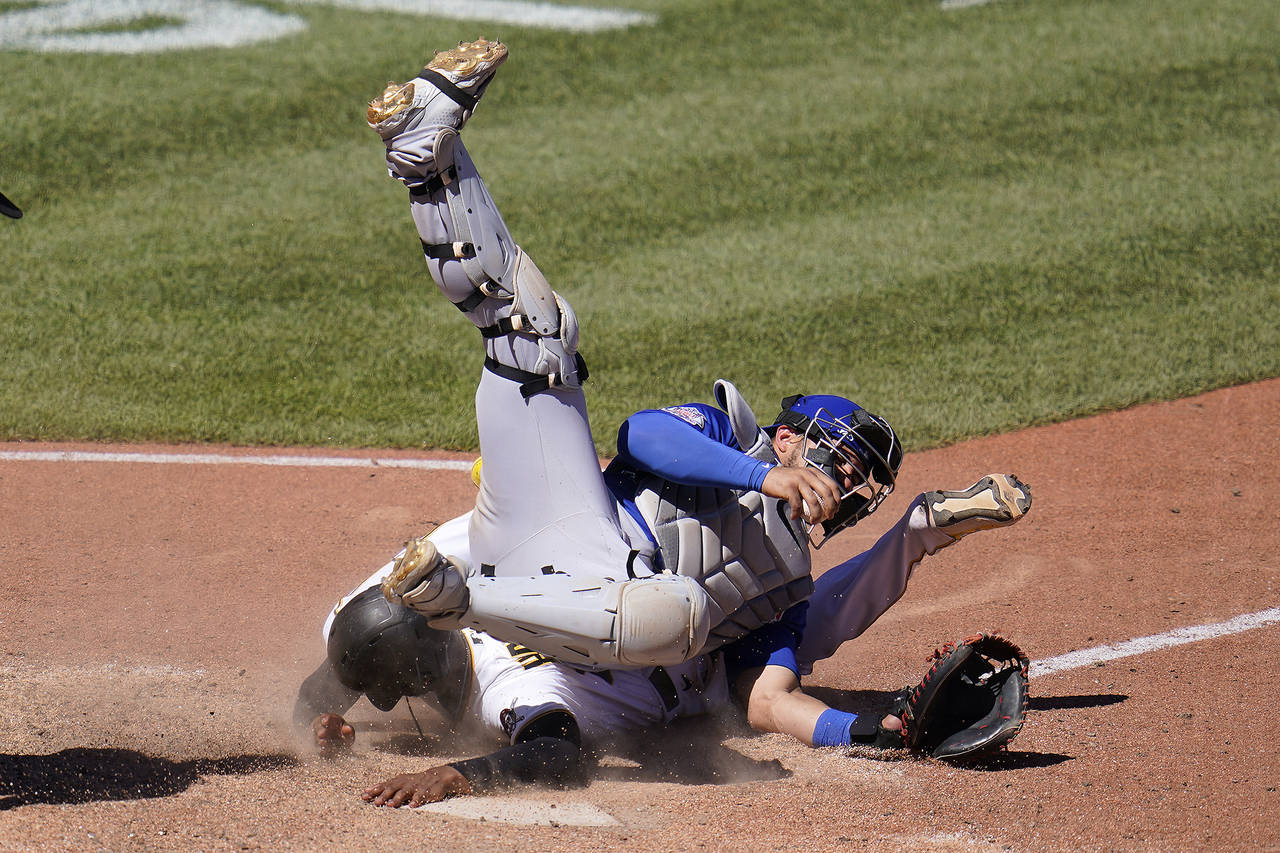 Pittsburgh Pirates' Ke'Bryan Hayes, bottom, scores as Chicago Cubs catcher Willson Contreras falls ...