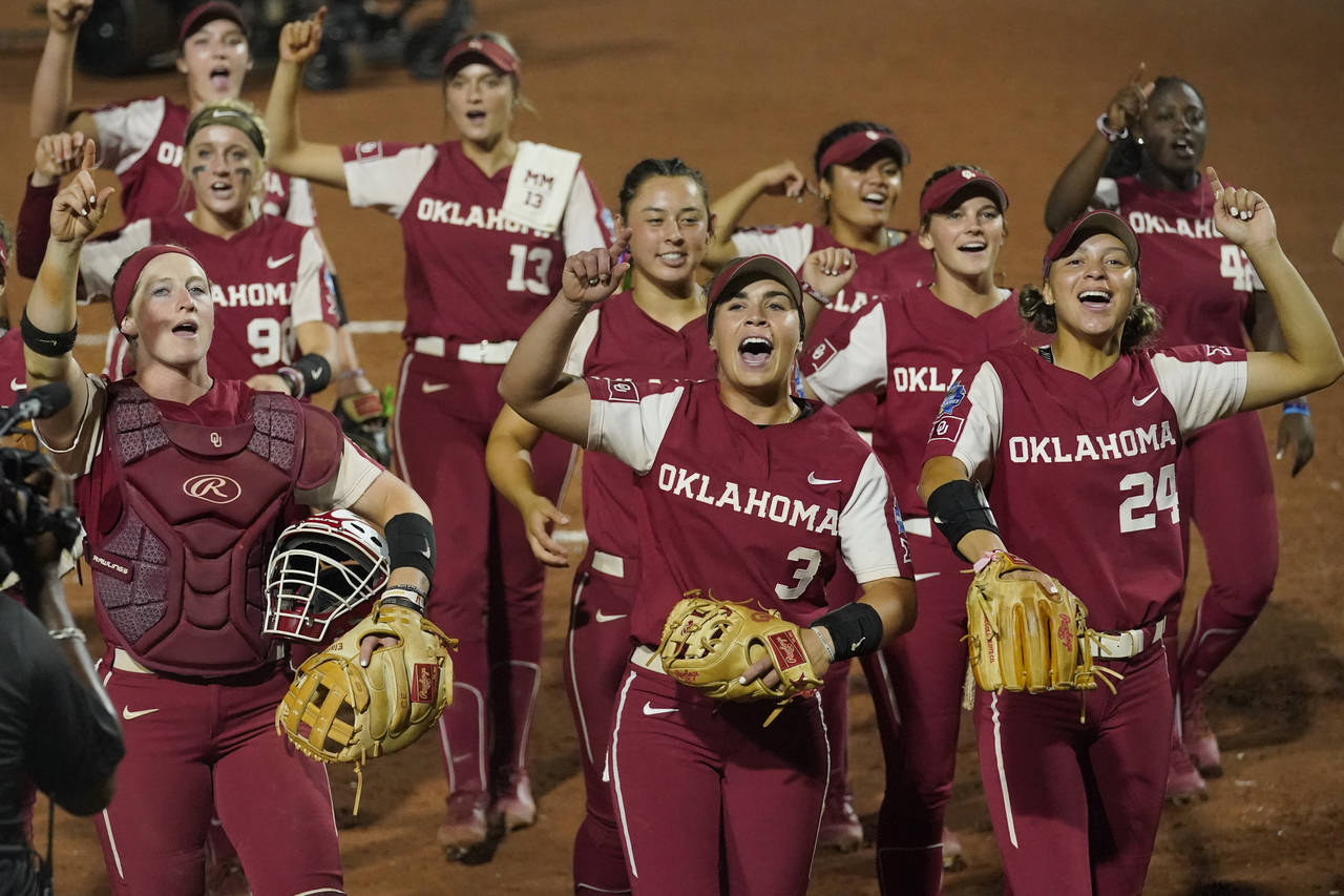 Oklahoma players celebrate and gesture to their fans after defeating Texas  16-1 in the first game ...
