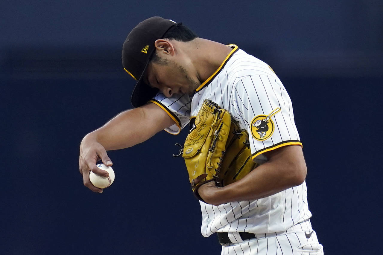 San Diego Padres starting pitcher Yu Darvish wipes his face with a sleeve as he works against a Ari...