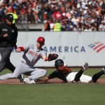 
              San Francisco Giants' Thairo Estrada, right, steals second base against Cincinnati Reds shortstop Kyle Farmer, center, during the fourth inning of a baseball game in San Francisco, Saturday, June 25, 2022. (AP Photo/Josie Lepe)
            