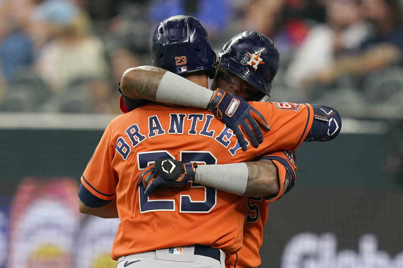 Houston Astros' Martin Maldonado, right hugs teammate Michael Brantley (23) after Maldonado hit a s...