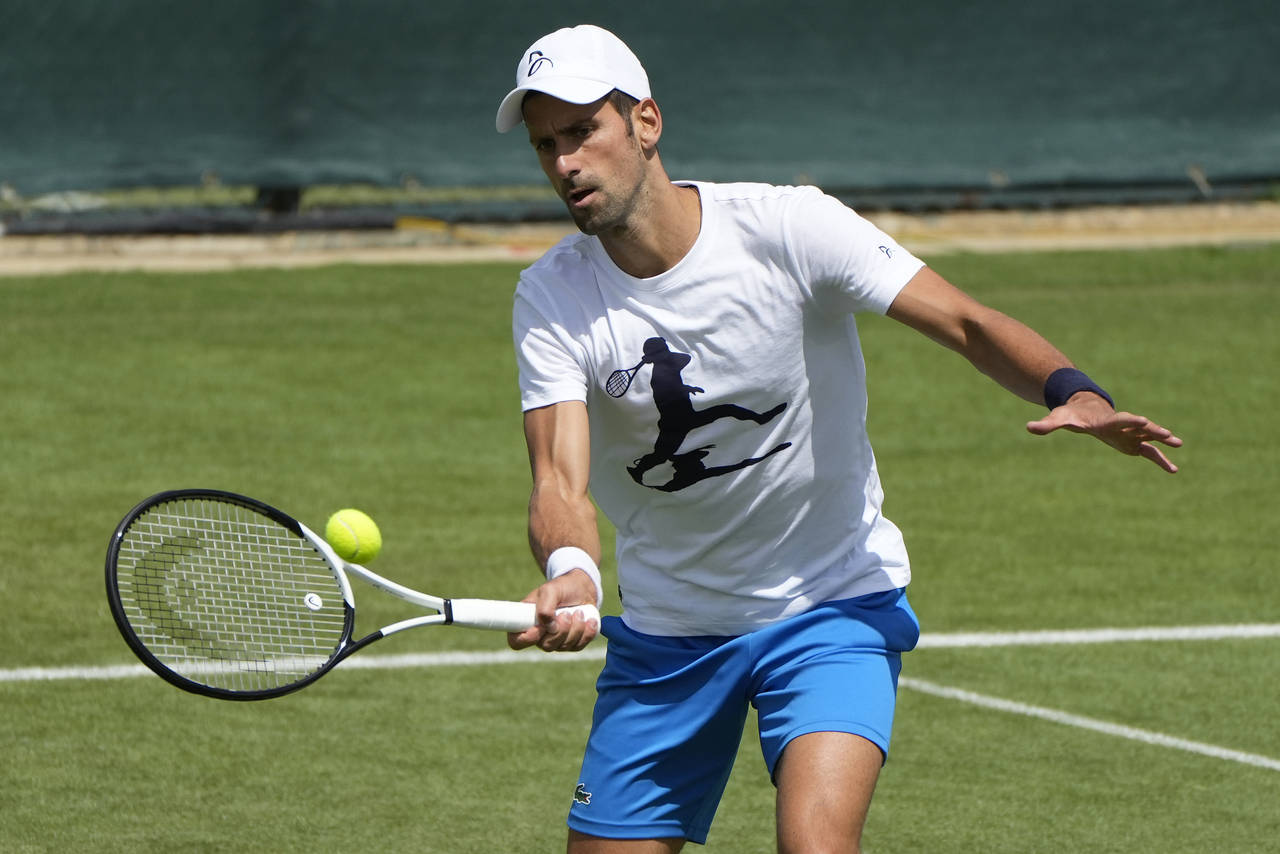 Serbia's Novak Djokovic plays a return as he practices ahead of the Wimbledon tennis championships ...