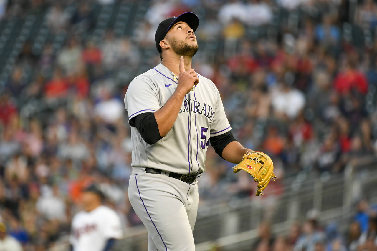Colorado Rockies pitcher Carlos Estevez gestures as he walks to the dugout after completing the sev...