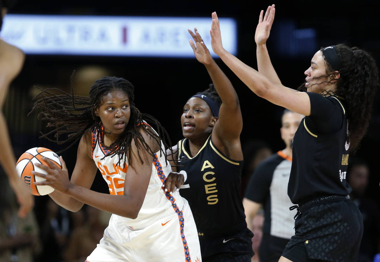 Connecticut Sun forward Jonquel Jones (35) is guarded by Las Vegas Aces guard Chelsea Gray (12) and...