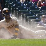 
              San Diego Padres' Jurickson Profar scores in a cloud of dust off a single by Manny Machado during the fourth inning of a baseball game against the Chicago Cubs Thursday, June 16, 2022, in Chicago. (AP Photo/Charles Rex Arbogast)
            