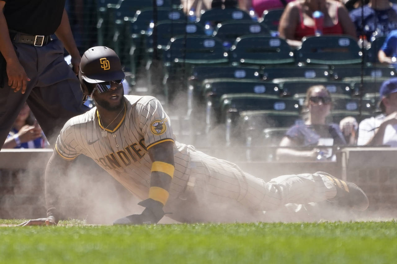 San Diego Padres' Jurickson Profar scores in a cloud of dust off a single by Manny Machado during t...