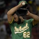 
              Oakland Athletics relief pitcher Lou Trivino wipes his brow with his jersey during the eighth inning of the team's baseball game agains the Boston Red Sox at Fenway Park, Wednesday, June 15, 2022, in Boston. (AP Photo/Mary Schwalm)
            