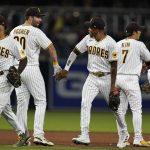 
              San Diego Padres right fielder Jose Azocar, third from left, celebrates with teammate first baseman Eric Hosmer and others after the Padres defeated the Colorado Rockies 9-0 in a baseball game Friday, June 10, 2022, in San Diego. (AP Photo/Gregory Bull)
            