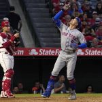 
              New York Mets' Brandon Nimmo, right, gestures as he scores after hitting a solo home run as Los Angeles Angels catcher Max Stassi stands at the plate during the fourth inning of a baseball game Friday, June 10, 2022, in Anaheim, Calif. (AP Photo/Mark J. Terrill)
            