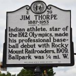 
              A state historical marker honoring 1912 Olympic gold medalist Jim Thorpe stands along a road in Rocky Mount, N.C. on Friday, May 27, 2022. A replacement marker was installed in mid-May,  more than two years after an earlier marker was accidentally torn down by a mowing service. The marker memorializes Thorpe playing baseball in Rocky Mount in 1909 (William F. West/Rocky Mount Telegram via AP)
            