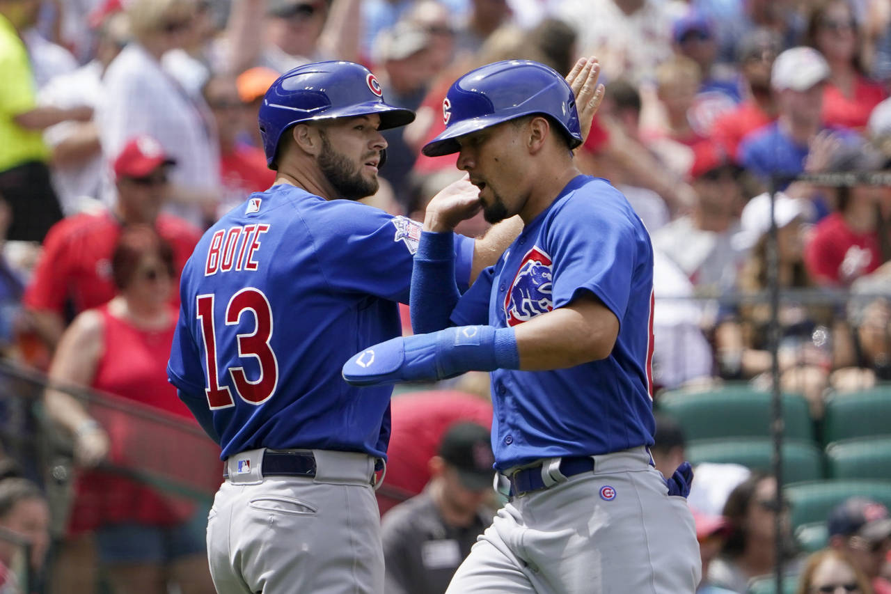 Chicago Cubs' David Bote (13) and Rafael Ortega celebrate after scoring during the fourth inning of...