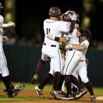 
              Texas A&M's Troy Claunch, center, is swarmed by teammates after driving in the winning run with a single against Louisville during an NCAA college baseball super regional tournament game early Saturday, June 11, 2022, in College Station, Texas. (AP Photo/Sam Craft)
            