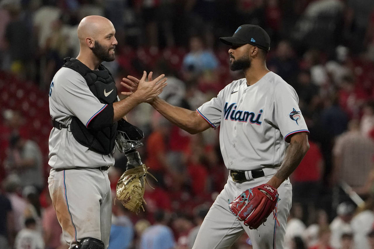 Miami Marlins starting pitcher Sandy Alcantara, right, is congratulated by teammate Jacob Stallings...