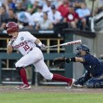 
              Oklahoma infielder Tanner Tredaway (10) hits an RBI single in the third inning against Notre Dame during an NCAA College World Series baseball game, Sunday, June 19, 2022, in Omaha, Neb. (AP Photo/John Peterson)
            