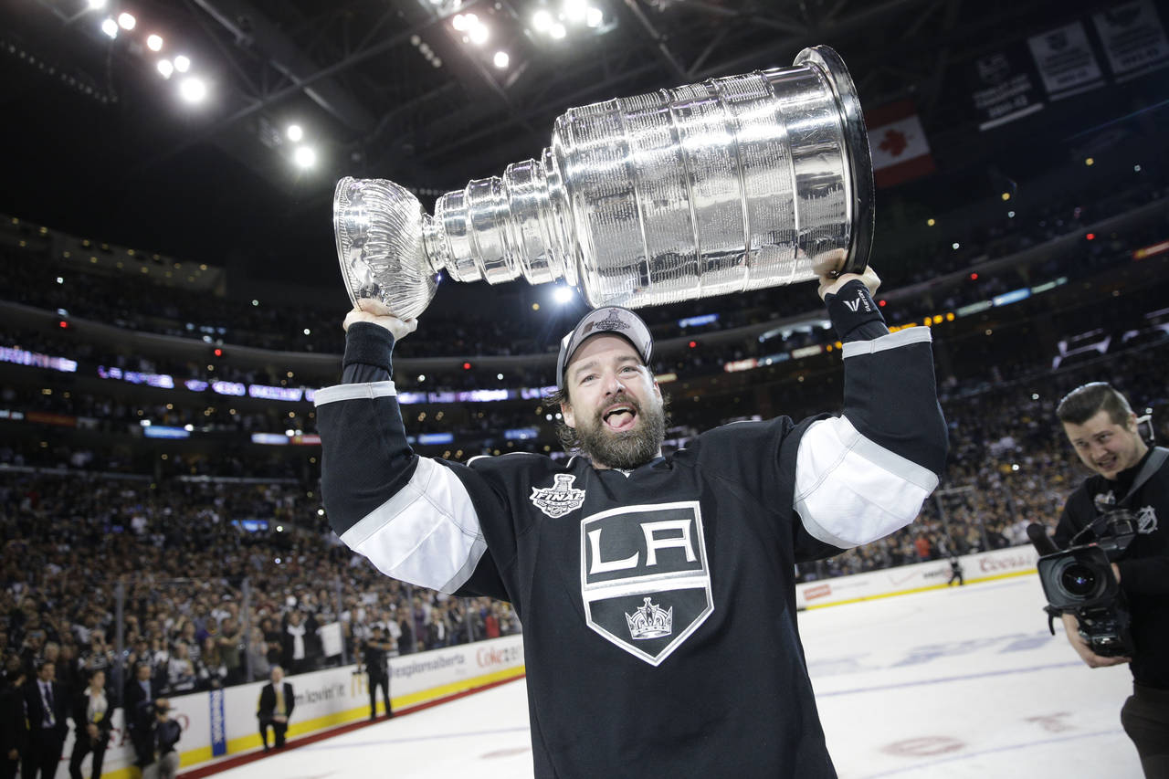FILE - Los Angeles Kings right wing Justin Williams, of Slovenia, carries the Stanley Cup after def...