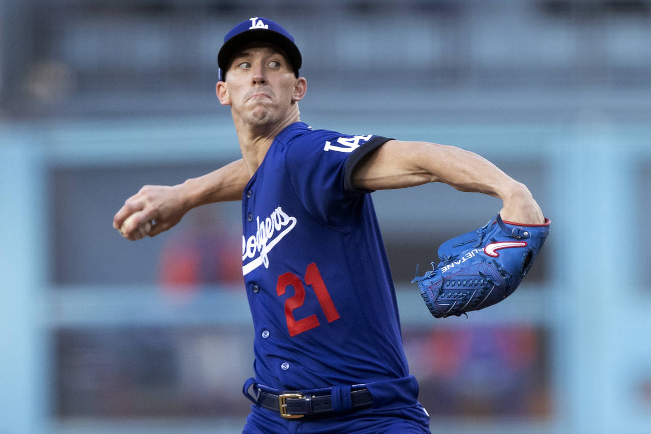 Los Angeles Dodgers starting pitcher Walker Buehler throws to a New York Mets batter during the fir...