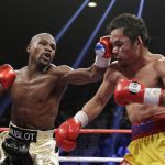 
              FILE - Floyd Mayweather Jr., left, hits Manny Pacquiao, from the Philippines, during their welterweight title fight on Saturday, May 2, 2015, in Las Vegas. Mayweather Jr. will be inducted into the Boxing Hall of Fame in Canastota, N.Y., on Sunday, June 12, 2022. (AP Photo/Isaac Brekken, File)
            