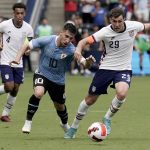 
              Uruguay midfielder Fernando Gorriaran (10) and USA defender Joe Scally (29) chase the ball during the first half of an international friendly soccer match Sunday, June 5, 2022, in Kansas City, Kan. (AP Photo/Charlie Riedel)
            