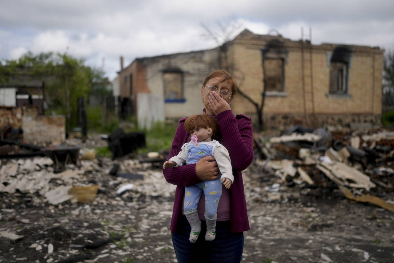 Nila Zelinska holds a doll belonging to her granddaughter, she was able to find in her destroyed ho...