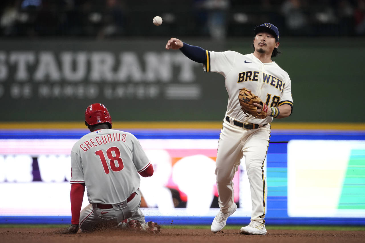 Milwaukee Brewers' Keston Hiura throws to first after forcing out Philadelphia Phillies' Didi Grego...