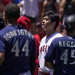 
              Seattle Mariners' Julio Rodriguez (44) is held back as Los Angeles Angels' Shohei Ohtani, center, watches while several members of the Mariners and the Angels scuffle after Mariners' Jesse Winker was hit by a pitch during the second inning of a baseball game Sunday, June 26, 2022, in Anaheim, Calif. (AP Photo/Mark J. Terrill)
            