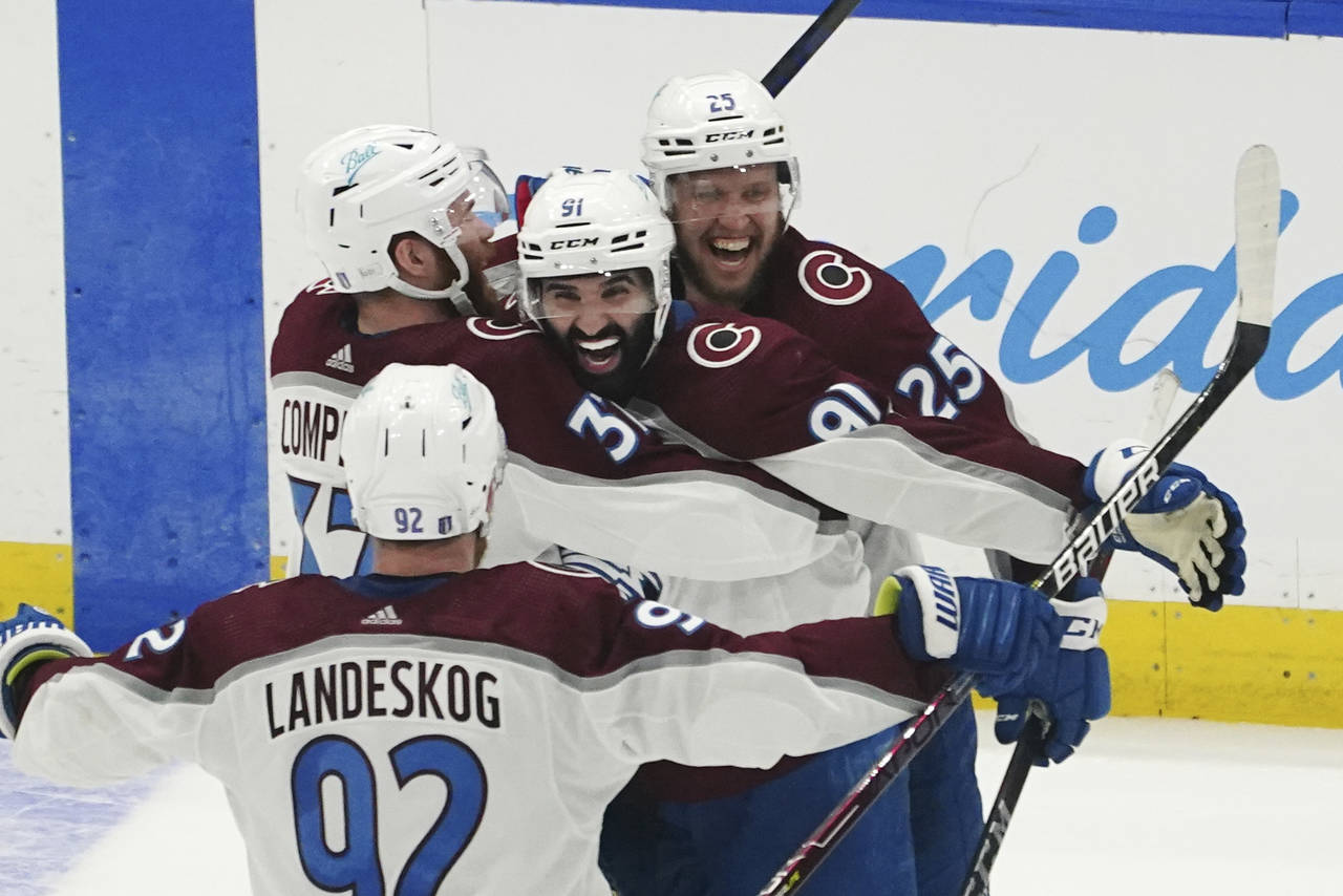 Colorado Avalanche center Nazem Kadri (91) is congratulated by teammates after his overtime goal on...