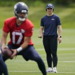 Amanda Ruller, who is currently working as an assistant running backs coach for the NFL football Seattle Seahawks through the league's Bill Walsh Diversity Fellowship program, watches as quarterback Jacob Eason takes snaps during NFL football practice on June 8, 2022, in Renton, Wash. Ruller's job is scheduled to run through the Seahawks' second preseason game in August. (AP Photo/Ted S. Warren)