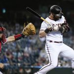 
              Arizona Diamondbacks' Christian Walker, right, backs away from an inside pitch as Cincinnati Reds catcher Chris Okey, left, reaches for the ball during the first inning of a baseball game Monday, June 13, 2022, in Phoenix. (AP Photo/Ross D. Franklin)
            