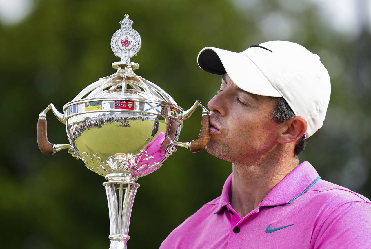 Rory McIlroy, of Northern Ireland, kisses the trophy after winning the Canadian Open golf tournamen...