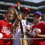 
              West Chester's Caden Marge, center, holds up signed memorabilia that he received from Philadelphia Phillies' Bryson Stott during warmups prior to a baseball game against the Arizona Diamondbacks, Friday, June 10, 2022, in Philadelphia. (AP Photo/Chris Szagola)
            