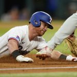 
              Texas Rangers' Kole Calhoun is tagged out by Philadelphia Phillies third baseman Alec Bohm, right, as Calhoun tried to reached third on a run-scoring double in the fifth inning of a baseball game, Wednesday, June 22, 2022, in Arlington, Texas. Adolis Garcia scored on the play. (AP Photo/Tony Gutierrez)
            