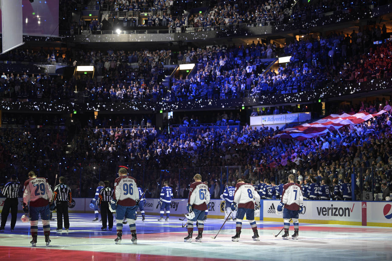 The Colorado Avalanche and the Tampa Bay Lightning stand during the national anthem before the firs...