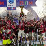 
              AC Milan's Alessio Romagnoli players holds up the trophy as he celebrates with teammates after winning the Italian Serie A title at the end of a match against Sassuolo, at the Citta del Tricolore stadium, in Reggio Emilia, Italy, Sunday, May 22, 2022. (AP Photo/Antonio Calanni)
            