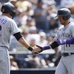 
              Colorado Rockies' Sam Hilliard, left, celebrates with Jose Iglesias, right, after crossing home plate on a two-RBI double by Ryan McMahon against the San Diego Padres during the eighth inning of a baseball game Sunday, June 12, 2022, in San Diego. (AP Photo/Mike McGinnis)
            