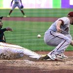 
              Pittsburgh Pirates' Ke'Bryan Hayes, left, scores on a wild pitch by Arizona Diamondbacks' Merrill Kelly, right, during the first inning of a baseball game in Pittsburgh, Friday, June 3, 2022. (AP Photo/Gene J. Puskar)
            