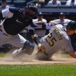 
              New York Yankees catcher Kyle Higashioka, left, can't make the tag on Oakland Athletics' Stephen Piscotty as he scores during the first inning of a baseball game at Yankee Stadium, Wednesday, June 29, 2022, in New York. (AP Photo/Seth Wenig)
            