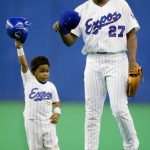 
              FILE - Montreal Expos' Vladimir Guerrero and his son Vladimir Jr. tip their caps to the crowd after Guerrero struck out in the eighth inning against Cincinnati Reds pitcher Joey Hamilton Sunday, Sept. 29, 2002 in Montreal. In all, more than two dozen major league offspring are on AL or NL rosters this year. The Blue Jays alone have three, including the sons of Hall of Famers Craig Biggio (Cavan) and Vladimir Guerrero (Vlad Jr.), along with Bo Bichette, whose father, Dante, was a four-time All-Star with the Rockies. (AP Photo/Paul Chiasson)
            