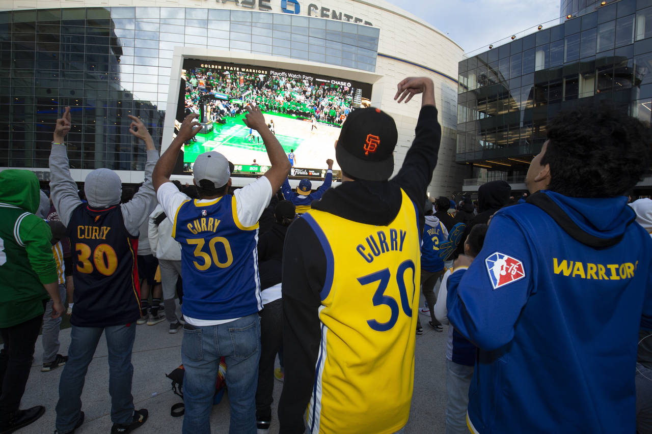 Golden State Warriors fans cheer on the team against the Boston Celtics during a watch party Thursd...