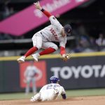 
              Boston Red Sox second baseman Trevor Story, top, leaps for the throw as Seattle Mariners' Dylan Moore, bottom, steals second during the seventh inning of a baseball game, Sunday, June 12, 2022, in Seattle. (AP Photo/John Froschauer)
            