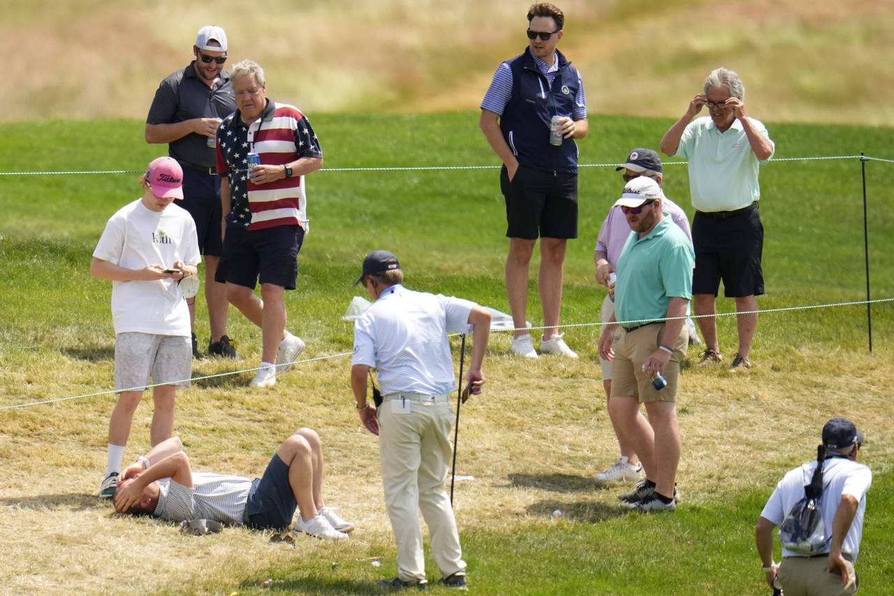 CORRECTS TO SAM HORSFIELD‬, OF ENGLAND, NOT PHIL MICKELSON - A fan, bottom left, reacts after bei...
