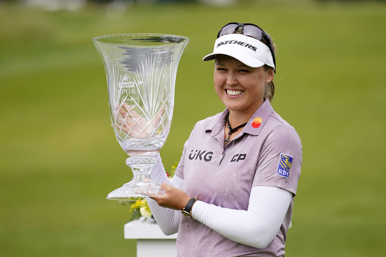 Brooke M. Henderson, of Canada, holds the trophy after winning the ShopRite LPGA Classic golf tourn...