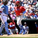 
              Philadelphia Phillies' Kyle Schwarber, right, comes home to score on a throwing error by Washington Nationals catcher Keibert Ruiz, left, on a pickoff-attempt during the fifth inning of a baseball game, Sunday, June 19, 2022, in Washington. (AP Photo/Nick Wass)
            