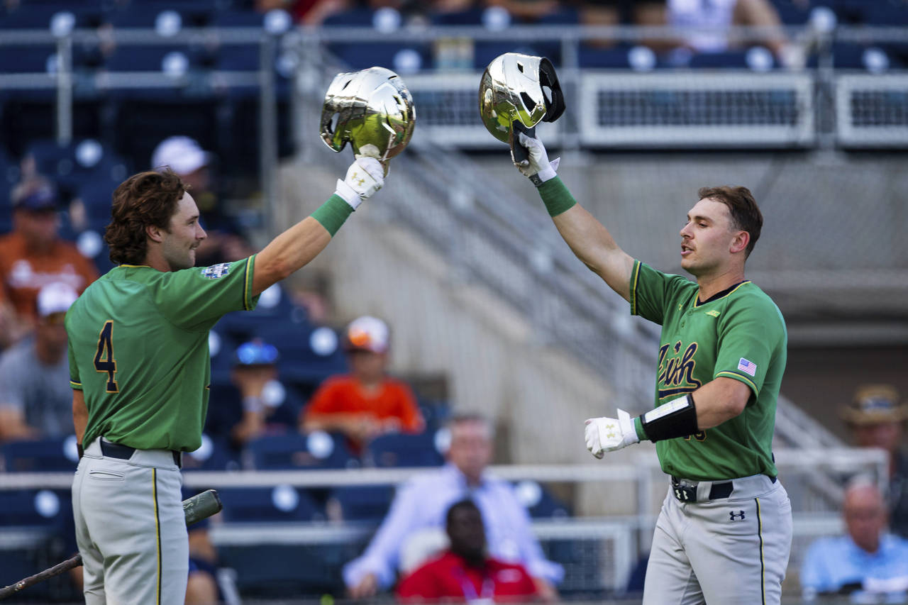 Notre Dame's Jared Miller (16) celebrates his home run against Texas with Carter Putz (4) during th...